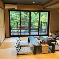 広々とした和室と撮影者の後ろにツインのベッドルーム